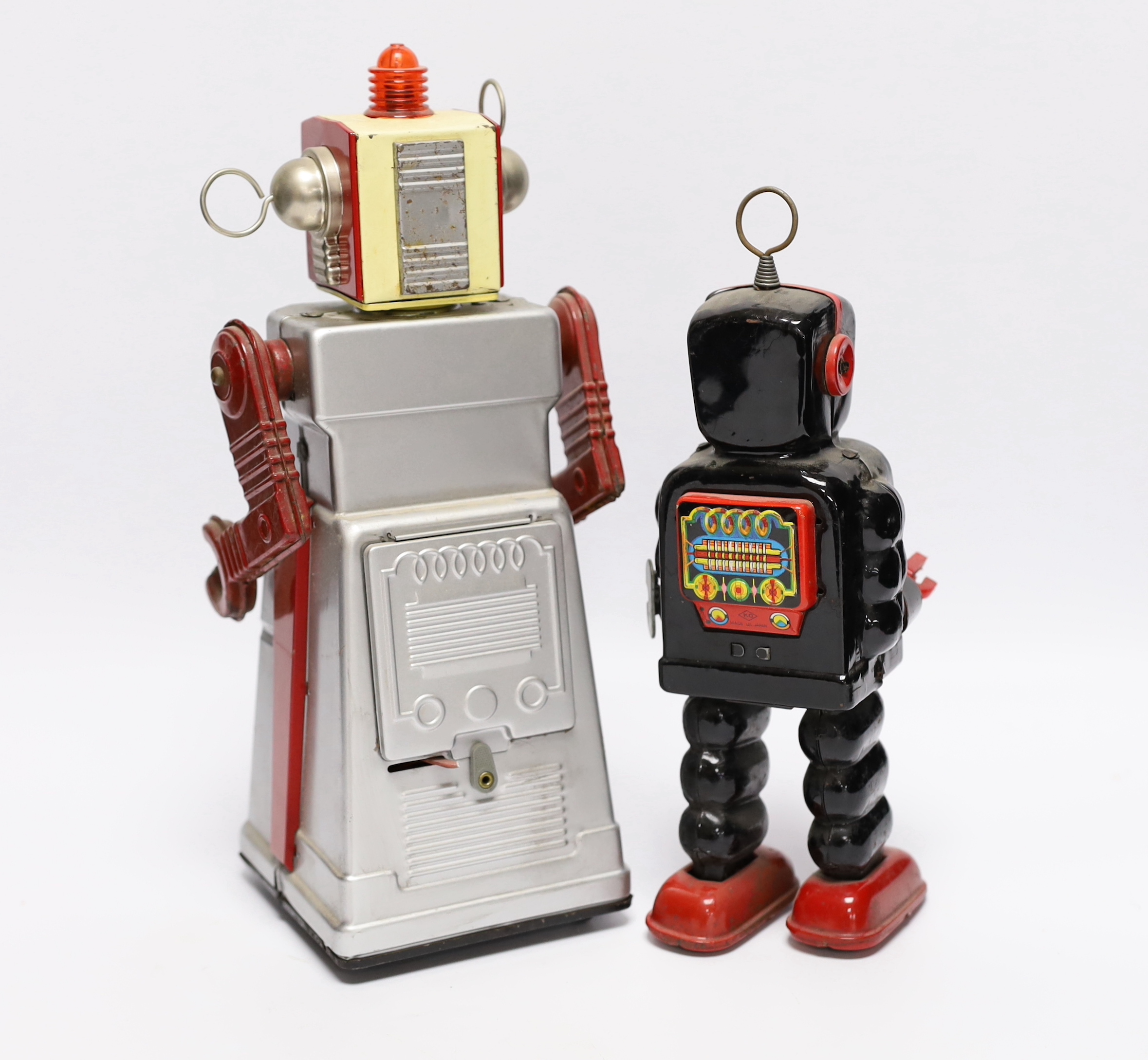 Four 1960s Japanese battery and clockwork powered robots, including; a boxed Horikawa (SH Toys) Fighting Robot, another smaller example by Horikawa, a Yoshiya (KO) silver robot and a Yoshhiya black clockwork robot, talle